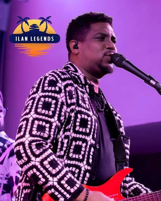 A singer-guitarist in a patterned jacket