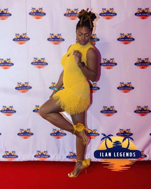 A guest in yellow posing on the red carpet