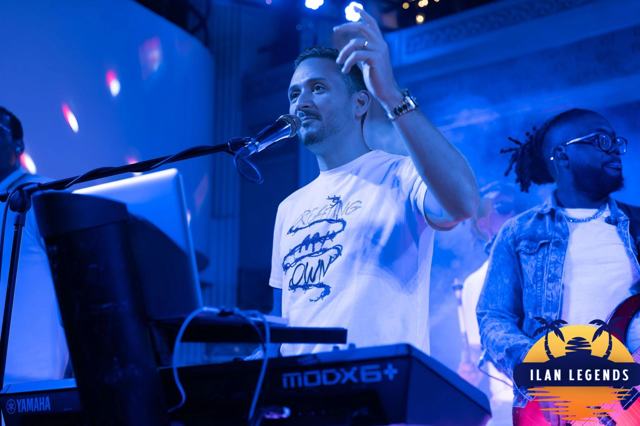A singer at the keyboard under blue light