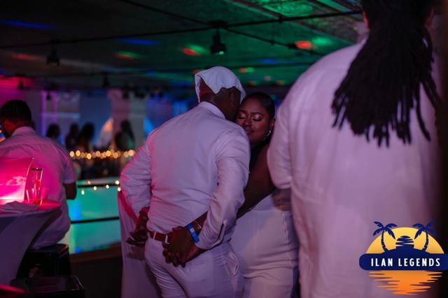 Guests in white dancing near the bar
